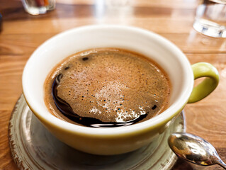 Green Coffee Cup on Wooden Cafe Table