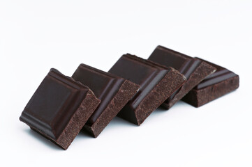 Dark chocolate chunks creating a diagonal line on white background