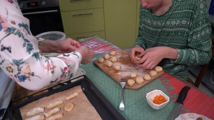 Teenager cooking cookies pastry. Grandmother makes the dough. Bake Christmas cookie. A boy prepares food in the kitchen. Baking tray on table - Powered by Adobe