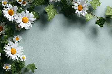 Floral arrangement of daisies and ivy leaves on a light green background