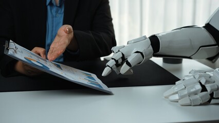 A robot hand interacts with a human during a business meeting, emphasizing innovation in data...