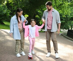 Happy family having fun with penny board in park