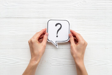 Hands are holding Question mark speech bubbles top view. FAQ concept
