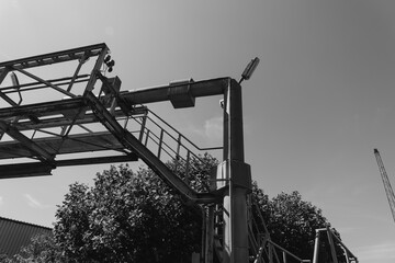 Sturdy construction framework rises against a bright sky while a crane looms in the background during a sunny afternoon
