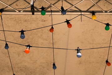 Colorful decorative lights create a festive atmosphere under a tent during an evening gathering in a warm summer setting
