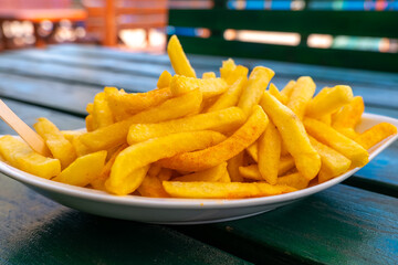 Savoring crispy golden fries served on a sunny day at an outdoor eatery
