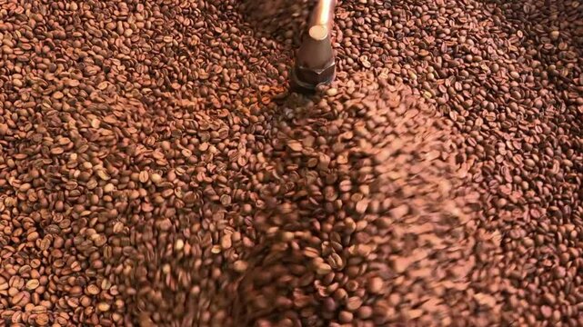 Coffee beans are being roasted in a large roasting machine