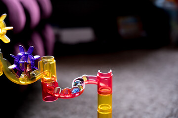 Selective focus on a toy marble run maze of multi-colored tunnels and turns 