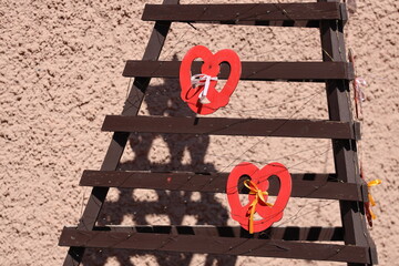 Couple's love symbol hanging from a wooden ladder, perfect for Valentine's Day or romantic decor