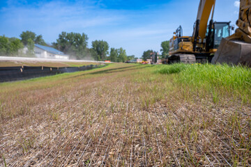 Woven straw mat used for stormwater erosion control with grass growing through 