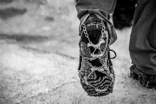 Selective focus on chain spikes on a pair of shoes for added traction on ice. 