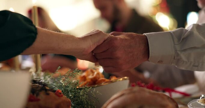 Holding hands, people and Christmas dinner with prayer for worship, gratitude or thanks to God for the food. Tradition, community or family with faith, saying grace or praise at holiday celebration - Powered by Adobe