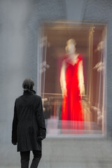 Rear view of a woman looking at a shop window in winter