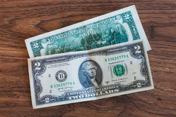 Two dollar bills on a table.
