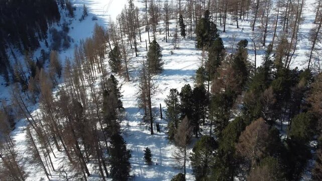 Drone aerial footage of a snowmobile riding across a frozen lake and snowy terrain in Russia. Captured from various angles, this footage highlights winter adventure, remote wilderness