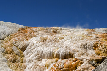 Scenic landscape view of steam rising from the Travertine Terraces at Mammoth Hot Springs in Yellowstone National Park