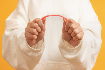 Hands bending a red rubber tube
