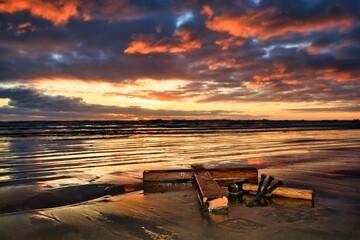 Wooden Cross Laid Down On Beach Sunset