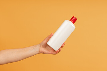 A hand holding a white plastic bottle upright © Sergey