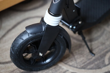 A close-up shot of a scooter resting on a colorful carpet