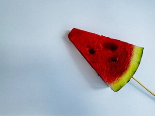 a slice of fresh watermelon on a stick