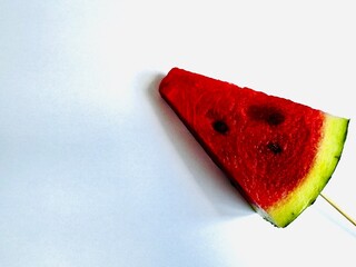 a slice of fresh watermelon on a stick