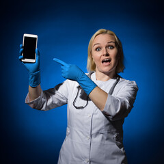 female doctor in a white coat with a stethoscope around her neck with a smartphone in her hands