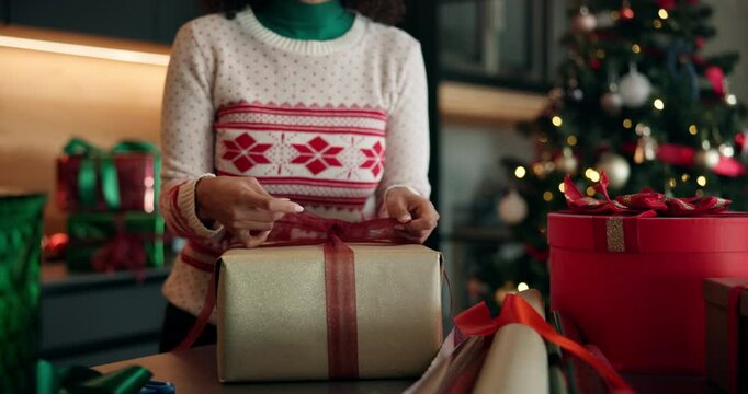 Ribbon, Christmas and gift with hands and wrapping paper for holiday season, celebration and bow. Present, festive tradition and package with person and box in home for decoration, parcel and event