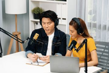 Smiling radio influencer hosts wearing headphones with channel social media online live streaming...