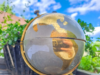 Old Globe with world map on blue sky background. Travel concept