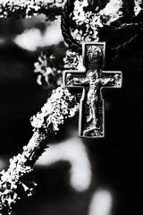 A monochrome image of a cross affixed to a tree branch, possibly used in various contexts such as...