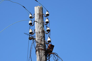 A utility pole with multiple wires and cables attached, great for illustrating infrastructure or...