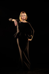 Woman in a black dress posing on a black background