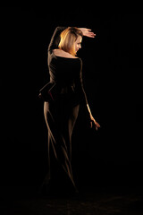 Woman in a black dress posing on a black background