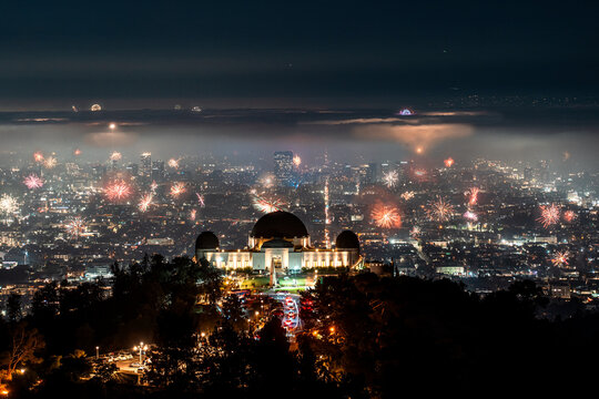 Griffith observatory at night with fireworks in the background