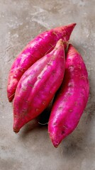 Vibrant purplepink sweet potatoes on smooth surface