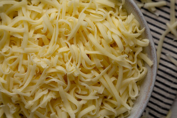 Organic Shredded Mozzarella Cheese in a Bowl, top view. Close-up.