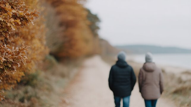 Two people walking on a path near a body of water