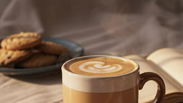 Cinnamon dust falling on steamy latte in slow motion cozy scene