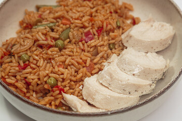 chicken fillet with rice cooked with vegetables in a bowl