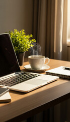 Freelancer home desk with cup of coffee, green leaves, notebook, and natural lighting from window