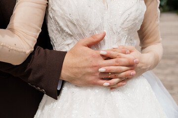 Intimate Wedding Moment: Couple Embracing with Focused Hands Holding Wedding Rings, Luxurious...