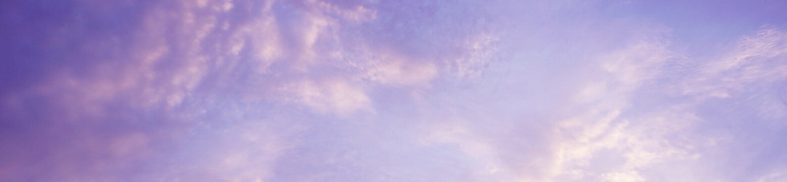 Blue purple lilac pink peach white orange gold yellow cloudy evening sky background. Sunset clouds sun summer. Delicate light pale pastel soft shades. Calm twilight sleep dream fantasy. Wide banner.