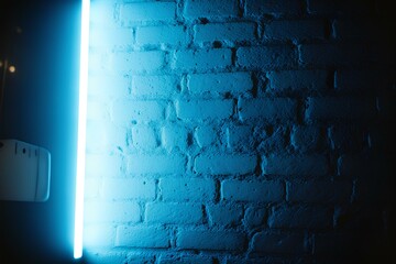Blue Neon Light on a Brick Wall at Night, Urban Futuristic LED Glow with Concrete Texture, Nightclub Atmosphere, Vibrant Cyberpunk Backdrop, Illuminated City Street Vibes