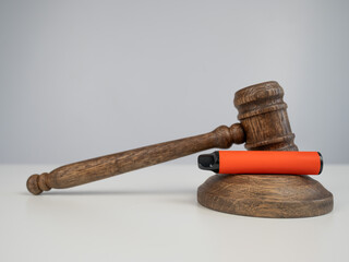 Judge's gavel and e-cigarette. Smoking ban. Tobacco heating systems. 