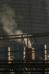 A noticeable plume of smoke is billowing out from the chimney located atop a factory building, indicating industrial activity within