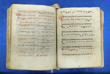 Open spread of a 13th-century Latin chant manuscript with square notation on four-line staves and...