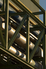 A cluster of pipes is carefully stacked on top of each other, resting on a sturdy metal structure...