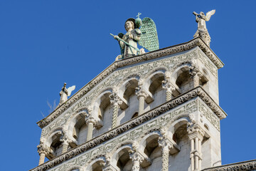 Facade of San Michele in Foro, Lucca, Italy, with arcades, decorative columns and marble sculpture...
