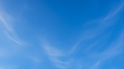 Bottom view straight up at vast deep blue sky with thin wispy cirrus clouds